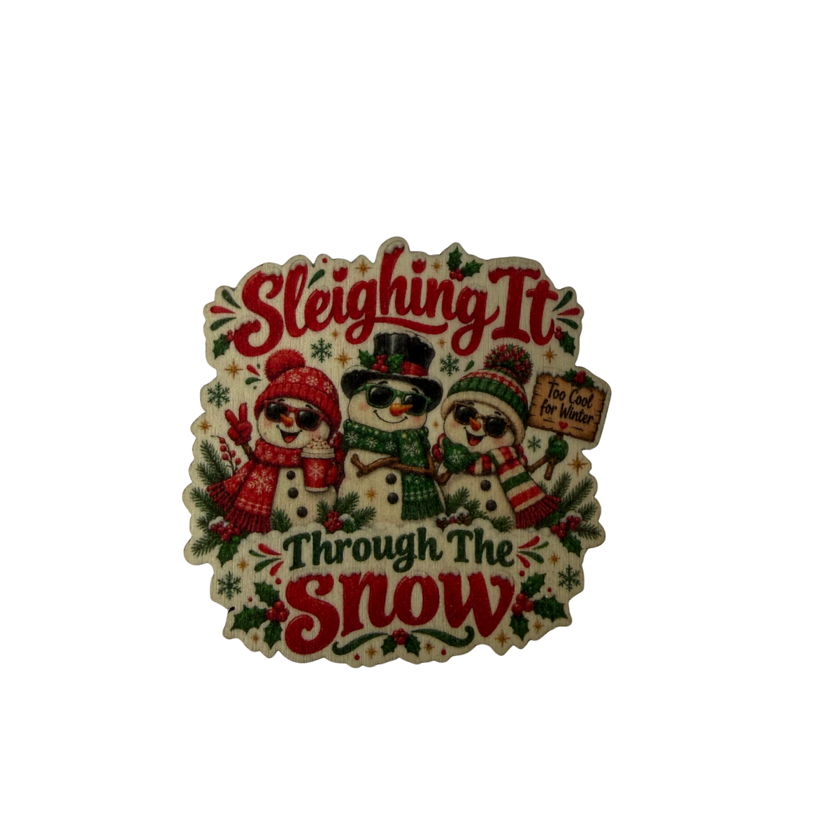 Wooden Christmas magnet featuring three snowmen in sunglasses and the words Sleighing It Through The Snow