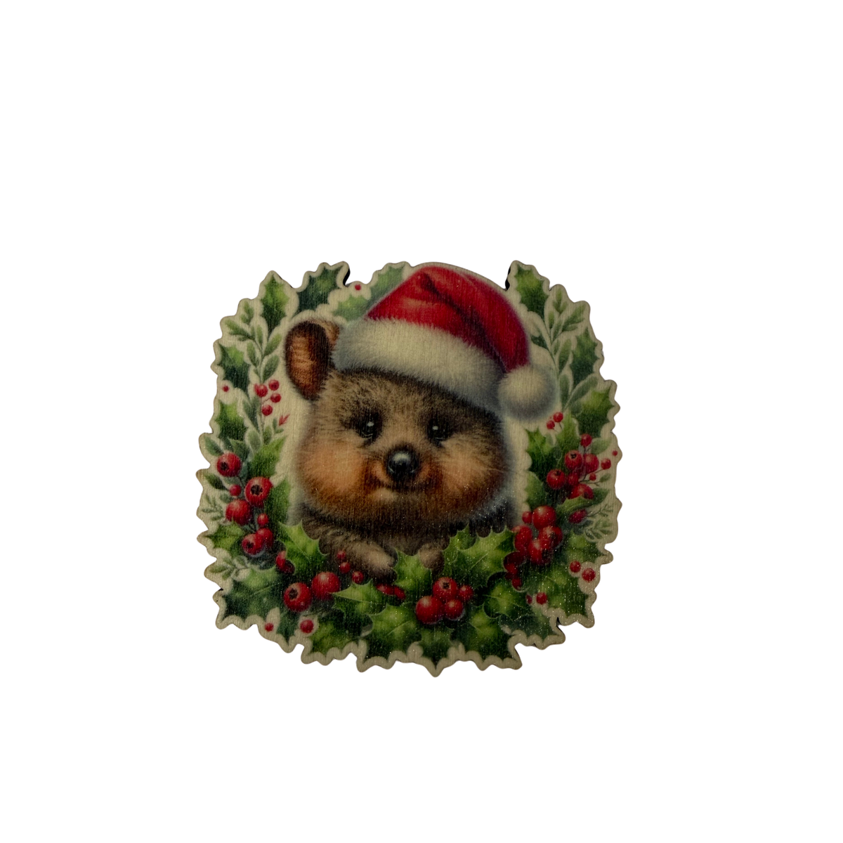Wooden quokka Christmas magnet wearing a red Santa hat, surrounded by festive greenery and red berries on a white background.
