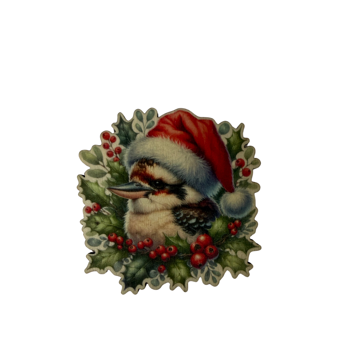 Wooden kookaburra Christmas magnet wearing a red Santa hat, surrounded by green foliage and red berries on a white background.