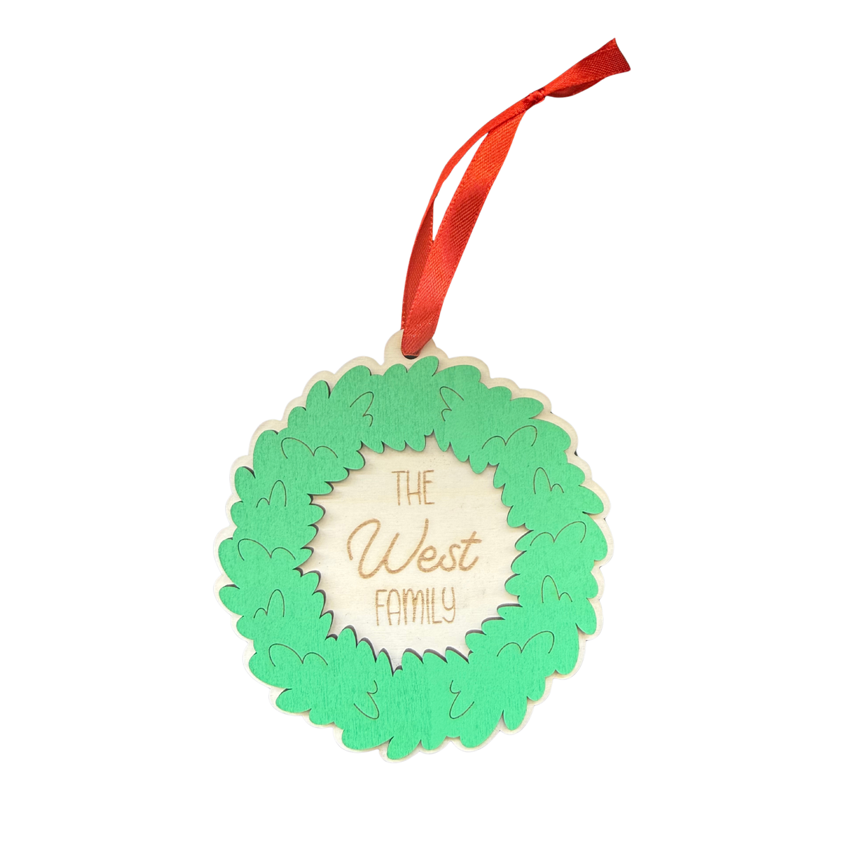 Personalised wooden Christmas wreath ornament with green leaves, West family engraving and red ribbon
