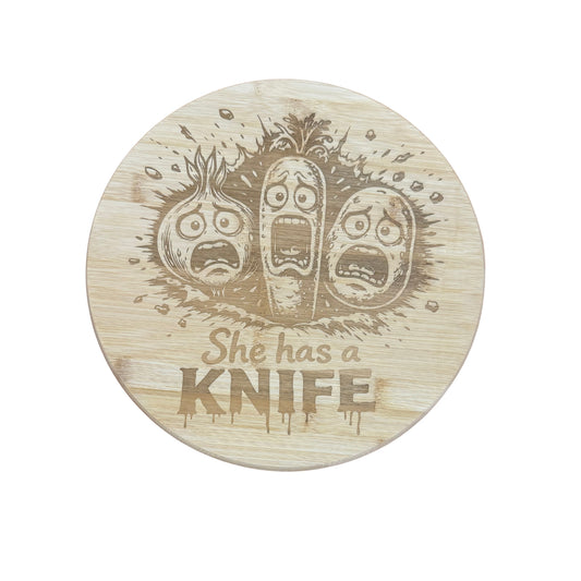 Round bamboo board engraved with the words She has a KNIFE and three cartoon vegetables